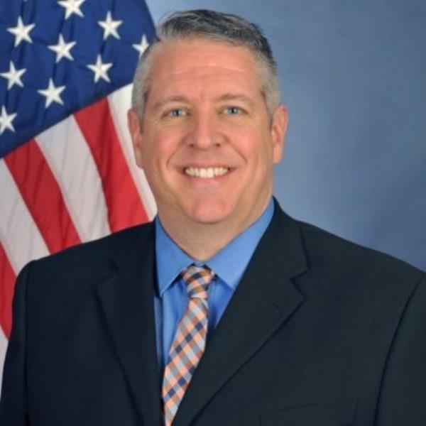Doug Ward headshot in front of American flag