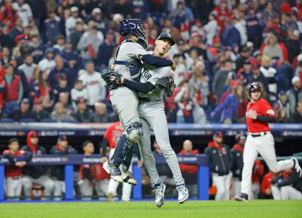Luke Weaver #30 of the New York Yankees celebrate with Austin Wells #28 of the New York Yankees after the final out of the 10th inning.