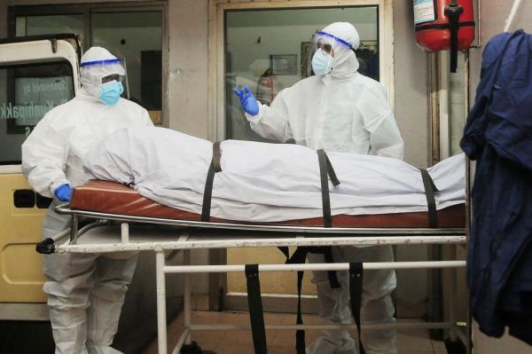 Health workers wearing protective gear move the body of a person who died of a Nipah virus infection at a hospital in India's Kerala state.
