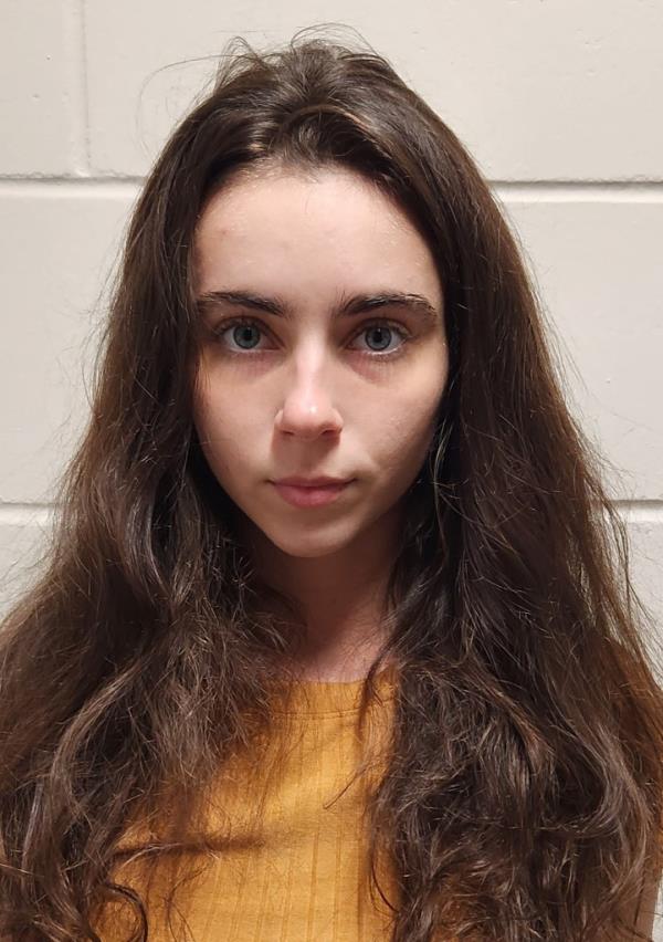 Mugshot of Rebekah Makenzie Tate in orange shirt