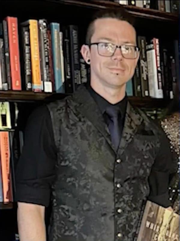 Image of John Powell in black suit.