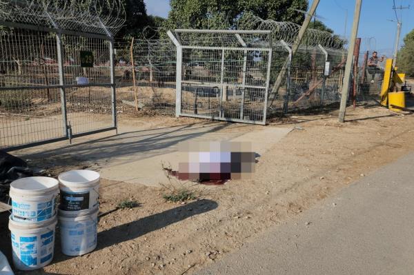 A man lies shot dead in the kibbutz of Kfar Azza
