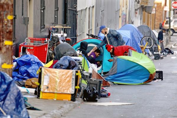 Homeless people co<em></em>nsume illegal drugs in an encampment along Willow St. in the Tenderloin district of downtown on Thursday, Feb. 24, 2022 in San Francisco, CA