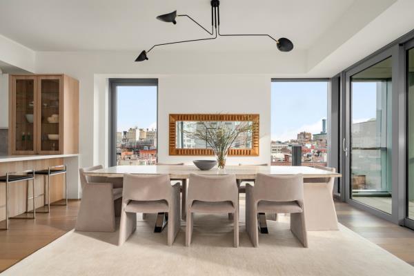 A sunny great room opens to the kitchen, as light streams in through floor-to-ceiling windows. 