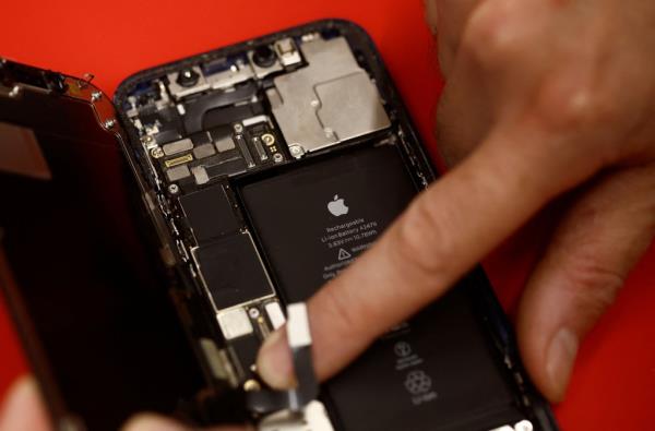 An employee checks an  iPhone 12 in a mobile phone store in Nantes, France, on Wednesday.