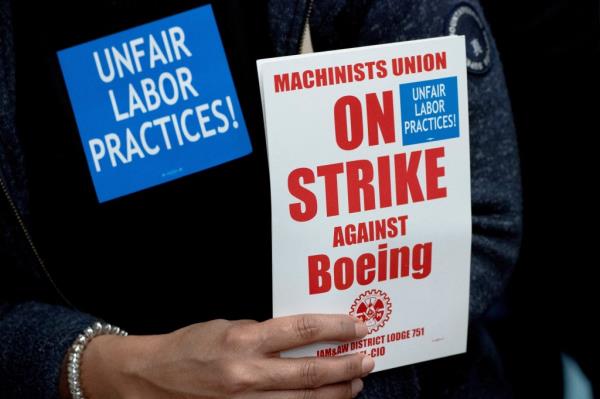 A Boeing worker from the Internatio<em></em>nal Association of Machinists and Aerospace Workers District 751 holds a sign while attending a rally at their unio<em></em>n hall during an o<em></em>ngoing strike in Seattle, Washington, U.S. October 15, 2024. REUTERS/David Ryder</p>

<p>　　