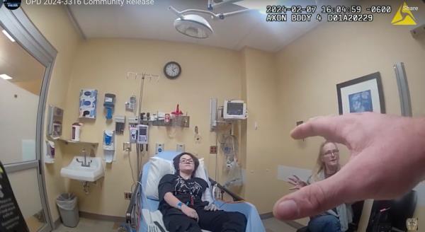 No<em></em>nbinary student Nex Benedict and mother speaking to a police officer in a hospital room after Nex was knocked down during a school fight.