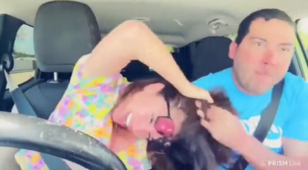 A man pulling Elisa Jordana's hair while she looks distressed. 