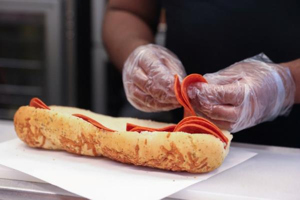 A person preparing a sub sandwich at a Subway restaurant in Manhattan, New York City on November 23, 2021.