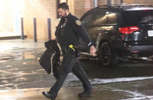 An officer walks near the scene in Queens.