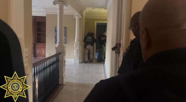 Authorities were seen combing through various rooms in the house.