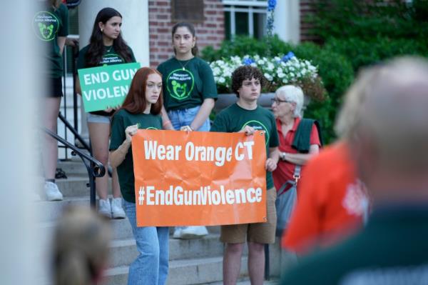 Members of Junior Newtown Action Alliance hold signs during a rally against gun violence on Friday, June 7, 2024 in Newtown, Conn. 