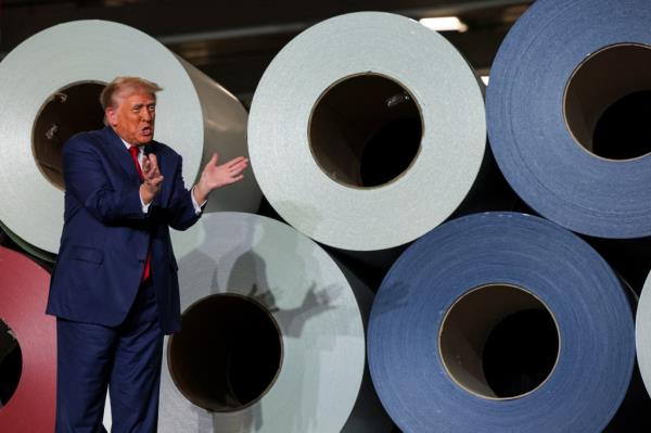 Former U.S. President Do<em></em>nald Trump, as Republican presidential nominee, standing in front of rolls of paper at FALK Production in Walker, Michigan during a campaign stop on September 27, 2024.