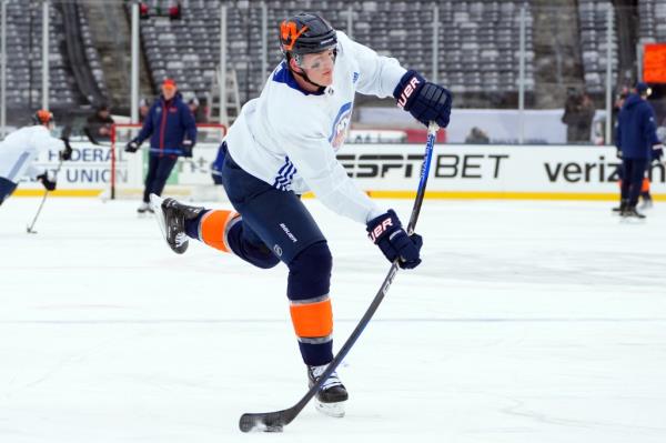 Hudson Fasching #20 of New York Islanders attempting a shot during 2024 Navy Federal Credit Unio<em></em>n Stadium Series on ice.