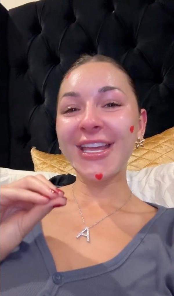 A woman, Anna Paul, smiling with red hearts on her face in a TikTok video