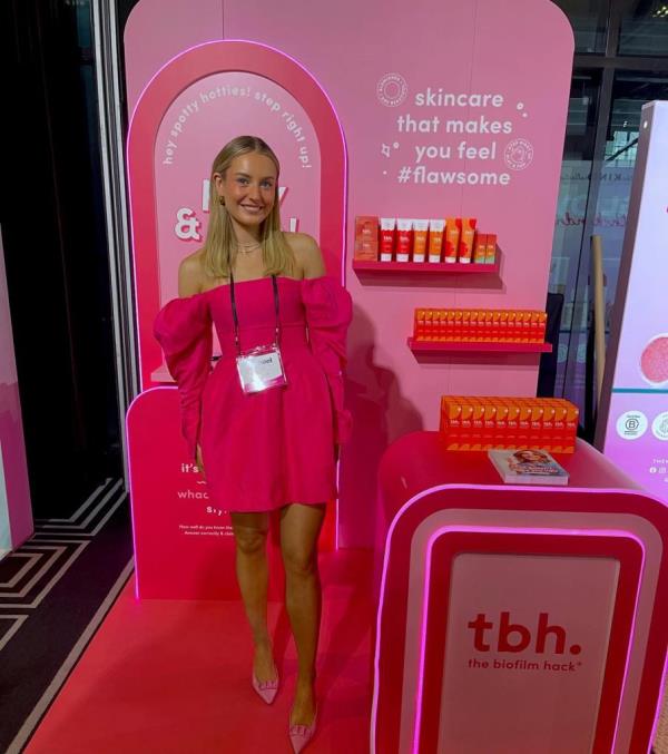 Rachael Wilde, co-founder of Aussie brand TBH Skincare, standing in front of a pink display