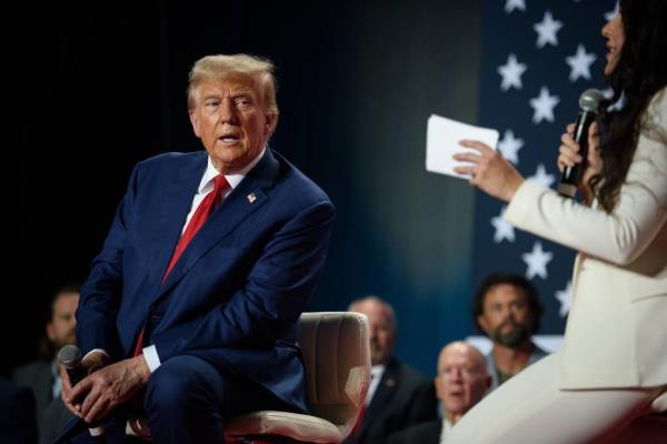 Republican presidential nominee Do<em></em>nald Trump sitting on a chair, listening to U.S. Rep. Anna Paulina Luna at a town hall, Crown Arena, October 4, 2024