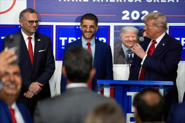 Former President Do<em></em>nald Trump speaking at a campaign office in Hamtramck, Michigan, while Hamtramck Mayor Amer Ghalib and Massad Boulos listen