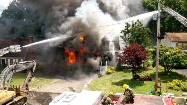 Firefighters attempting to co<em></em>ntrol a fire in a residential garage filled with fireworks during a thunderstorm