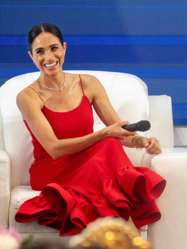 Meghan, Duchess of Sussex, in a red dress, co-hosting a Women in Leadership event with Dr. Ngozi Okonjo-Iweala in Abuja, Nigeria