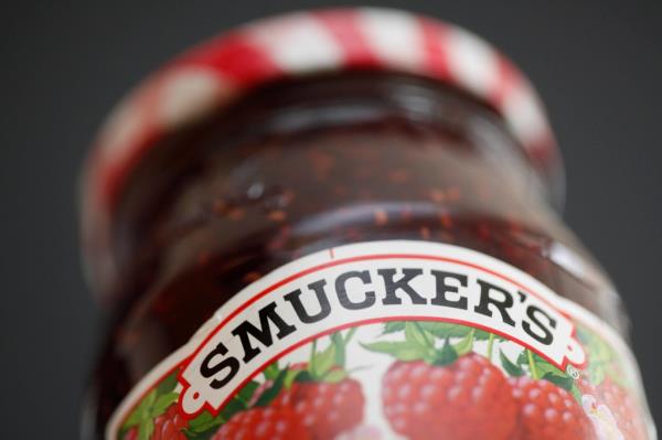 Close-up view of a jar of Smucker's preserves on a shelf.