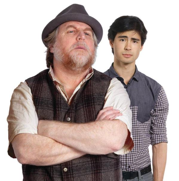 Actor Julien Arnold, with arms crossed, standing next to a man in a hat during a theater performance