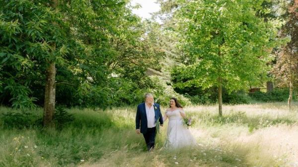 Actor Julien Arnold and his wife Sheiny Satanove walking in a field on their wedding day
