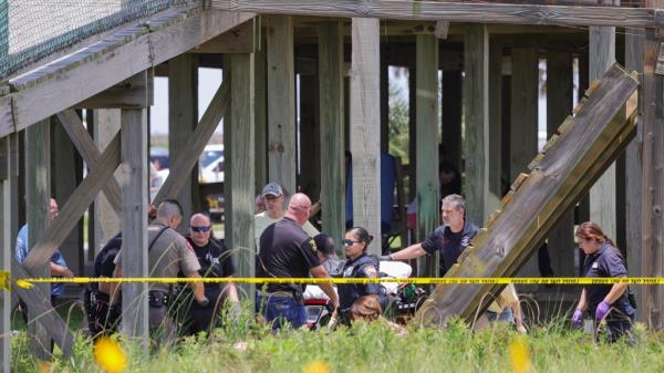 First respo<em></em>nders at the scene of a boardwalk collapse behind police tape.