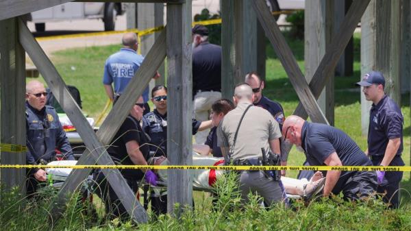 First respo<em></em>nders carry a teen on a stretcher below a raised boardwalk that collapsed in one section. 