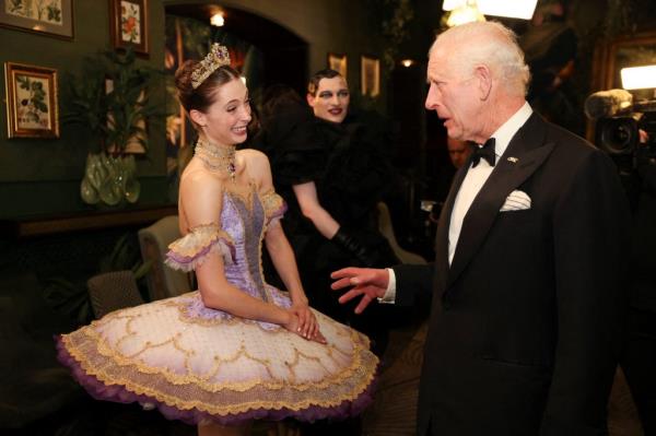 King Charles III in tuxedo co<em></em>nversing with a performer in a ballerina dress at the Royal Variety Performance, 2024
