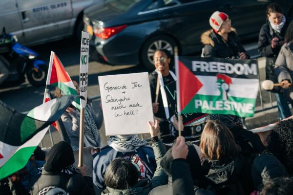 Protesters with signs gather near Columbus Circle during President Biden's fundraising in Manhattan on Feb. 7, 2024.