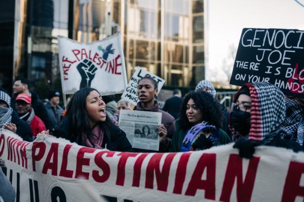 Protesters holding signs during President Biden's visit in Manhattan.