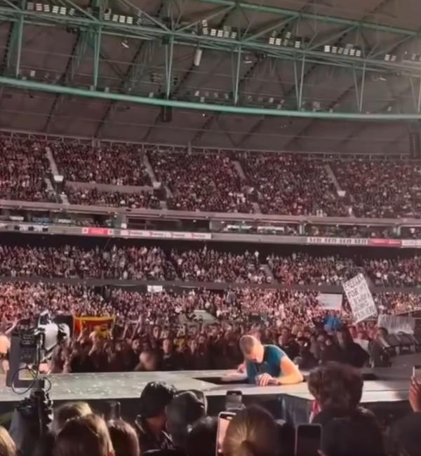 Chris Martin falls backwards through trap door.