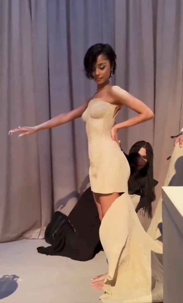 Designer Rousteing expertly tailoring the hemline of Tyla's sand gown at the Met Gala