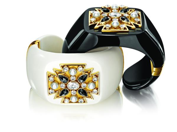 Image of two interlocking black and white cuffs with gold accents