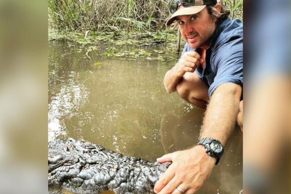 Australian crocodile hunter touching crocodile