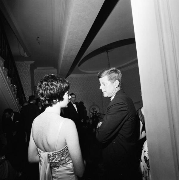 President John F. Kennedy visits with entertainer, Shirley MacLaine, during an evening reception at the residence of Arthur B. Krim and Dr. Mathilde Krim in New York City, New York.