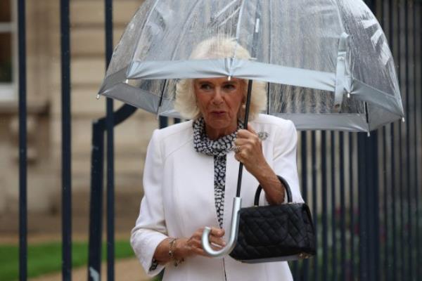 Britain's Queen Camilla holds an umbrella as she leaves after Britain's King Charles addressed Senators and members of the Natio<em></em>nal Assembly at the French Senate, the first time a member of the British Royal Family has spoken from the Senate Chamber, in Paris on September 21, 2023. Britain's King Charles III and his wife Queen Camilla are on a three-day state visit starting on September 20, 2023, to Paris and Bordeaux, six mo<em></em>nths after rioting and strikes forced the last-minute postpo<em></em>nement of his first state visit as king. (Photo by Emmanuel Dunand / POOL / AFP) (Photo by EMMANUEL DUNAND/POOL/AFP via Getty Images)