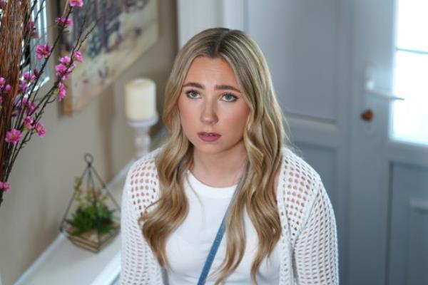 Peri Lomax in a house looking up the stairs in Hollyoaks