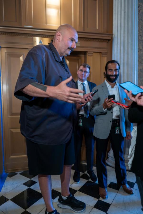 Fetterman speaking to reporters in the Capitol building while wearing shorts on September 19, 2023.