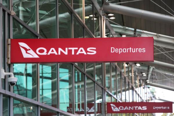 Qantas signage displayed at Sydney Airport terminal reflecting the airline's full-year financial results
