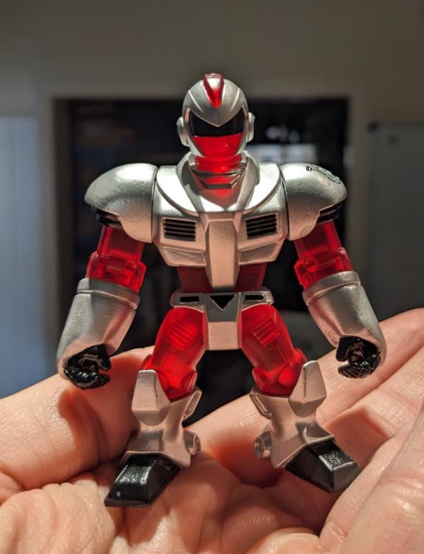 Dan Larson holding a tiny action figure in his hand.