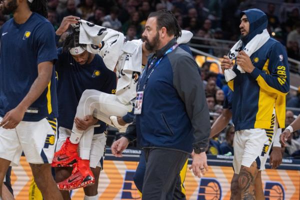 Pacers guard Tyrese Haliburton (0) is carried off the court with apparent leg injury