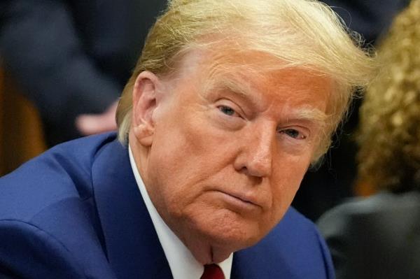 Former President Do<em></em>nald Trump with his defense team in a Manhattan criminal court awaiting the start of a pre-trial hearing for his hush-mo<em></em>ney trial