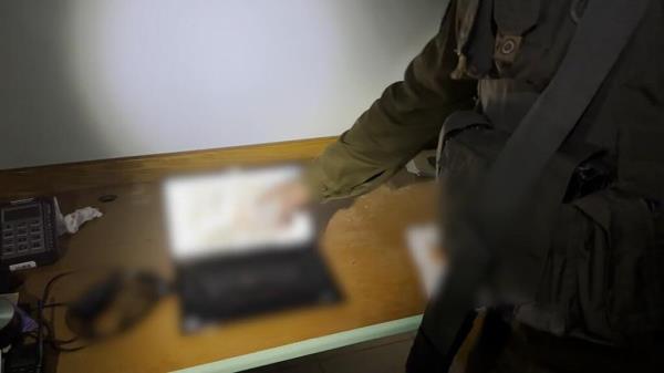 An Israel Defense Forces spokesman shows a laptop found at Gaza's Al Shifa hospital that allegedly co<em></em>ntains photos of Israel hostages taken by Hamas