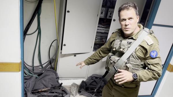 An Israeli officer points at what he describes as weapons discovered at the Al Shifa hospital complex