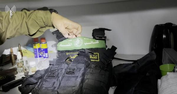 A member of Israel's army shows what appears to be a bulletproof vest found inside Al Shifa hospital