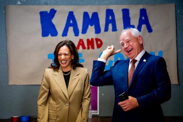 Democratic presidential candidate, U.S. Vice President Kamala Harris and Democratic vice presidential candidate Minnesota Gov. Tim Walz laugh after taking a selfie in front of a sign that reads