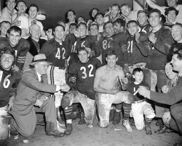 Chicago Bears' quarterback Johnny Lujack is co<em></em>ngratulated by coach George Halas, left, on setting a Natio<em></em>nal League aerial gain record of 468 yards in defeating their rivals, the Chicago Cardinals.
