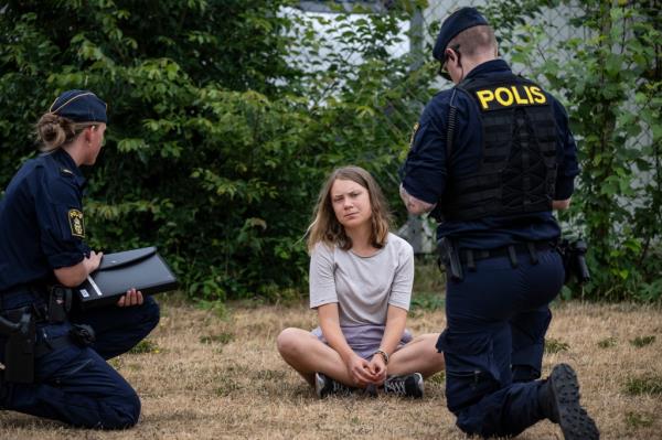 Police officers talk to the Swedish climate activist Greta Thunberg as they move activists from the organization 'Ta Tillbaka Framtiden' (Take back the future) who are blocking the entrance to the Oljehamnen neighbourhood in Malmo, Sweden, Monday, June 19, 2023